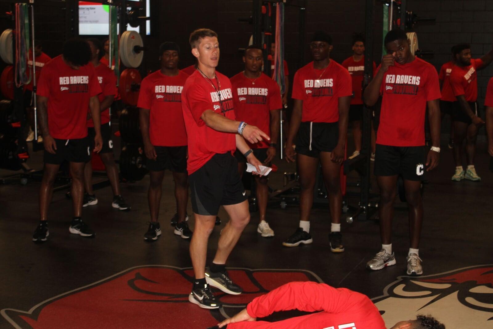 AthleteBuilder coach leading a group in a weight room